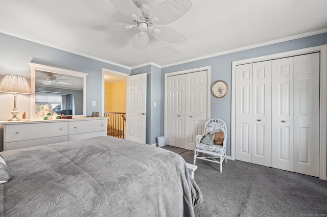 carpeted bedroom with ornamental molding, two closets, a ceiling fan, and baseboards