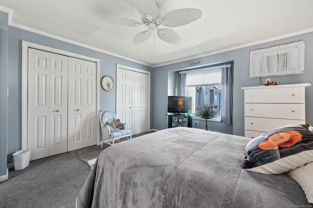 carpeted bedroom with a ceiling fan, a textured ceiling, ornamental molding, and multiple closets