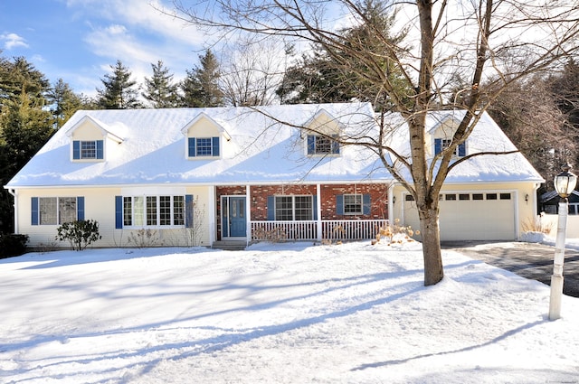 cape cod house with a garage, covered porch, brick siding, and driveway