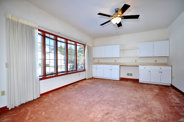 kitchen featuring carpet floors, visible vents, and built in study area