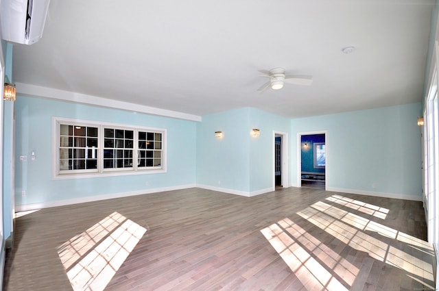 empty room featuring ceiling fan, baseboards, and wood finished floors