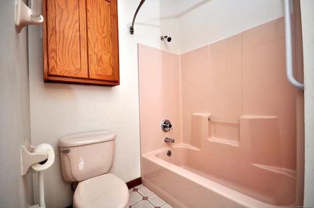 bathroom featuring toilet, baseboards, and  shower combination