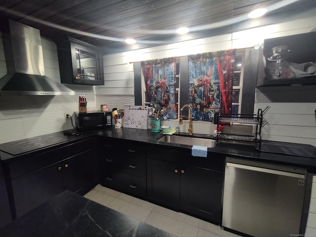 kitchen with dark countertops, a sink, wall chimney range hood, and black appliances