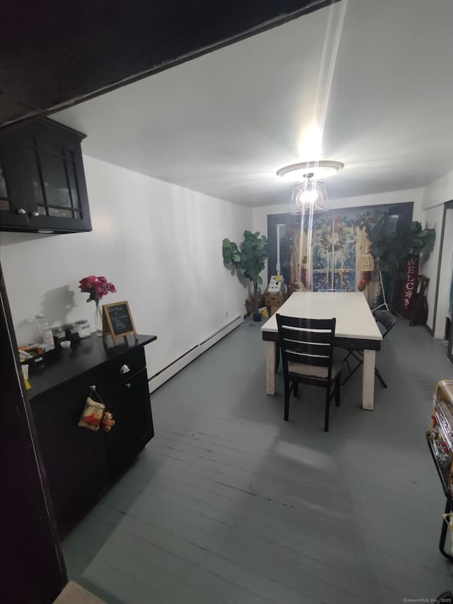 dining room featuring a baseboard heating unit and wood finished floors