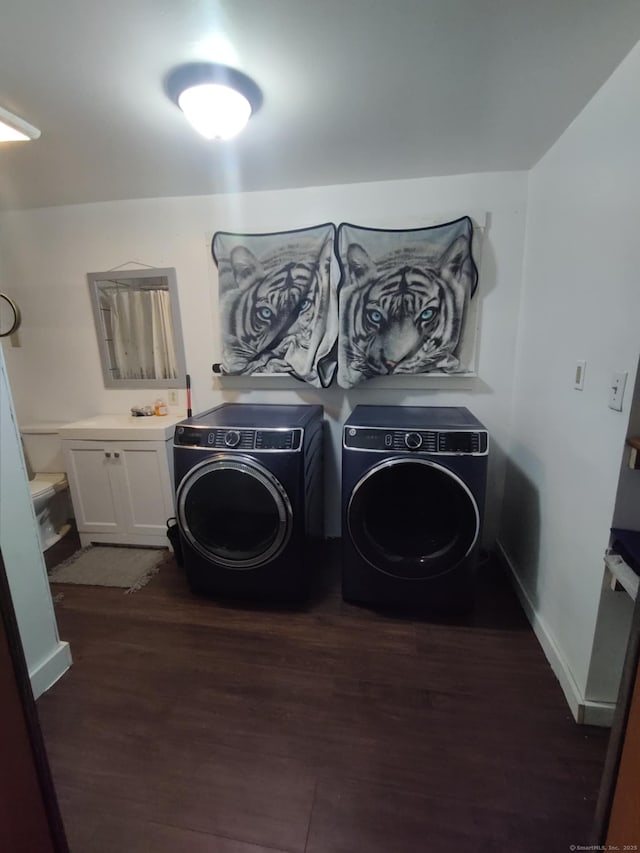 laundry room featuring cabinet space, baseboards, separate washer and dryer, and dark wood-type flooring