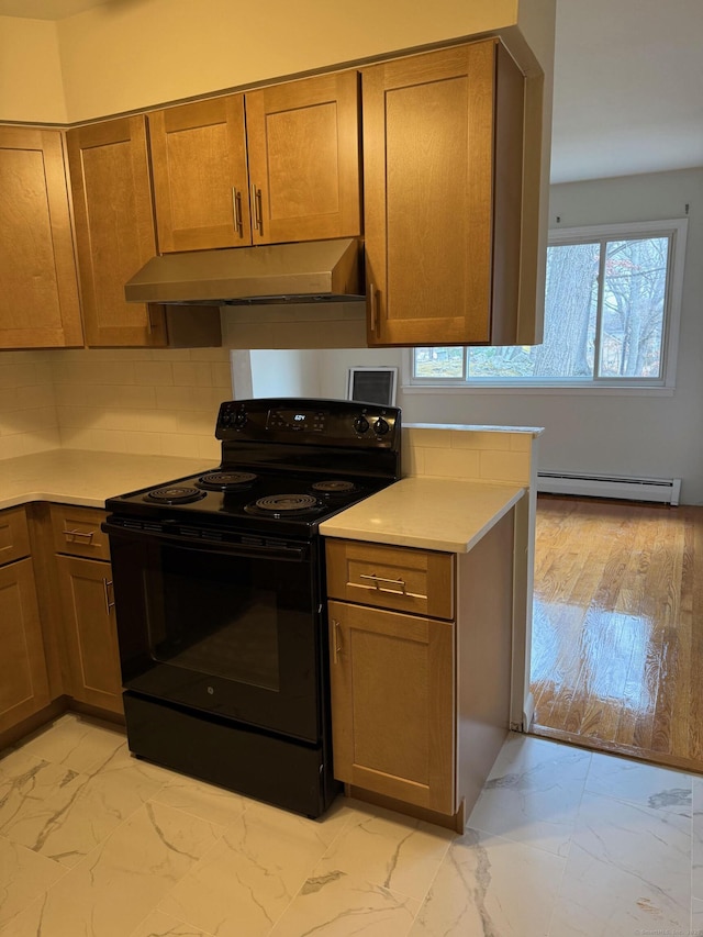 kitchen featuring under cabinet range hood, black range with electric cooktop, marble finish floor, and a baseboard heating unit