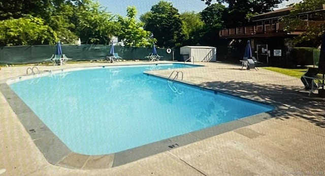 pool featuring a patio area and fence