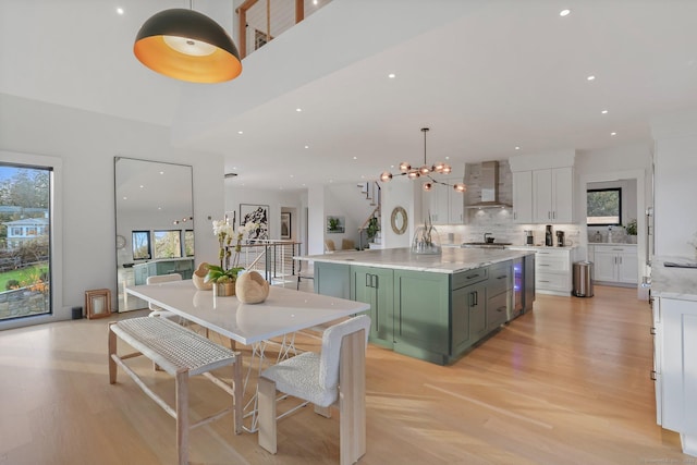 interior space featuring wall chimney exhaust hood, plenty of natural light, white cabinets, and green cabinetry