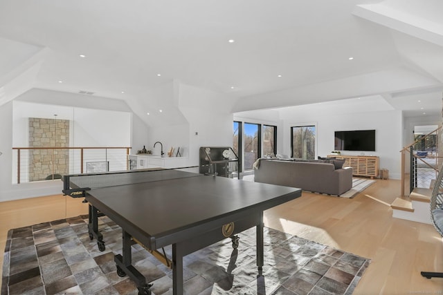 recreation room featuring lofted ceiling, light wood-type flooring, visible vents, and recessed lighting