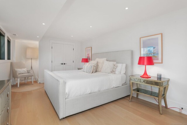 bedroom with baseboards, a closet, light wood-style flooring, and recessed lighting