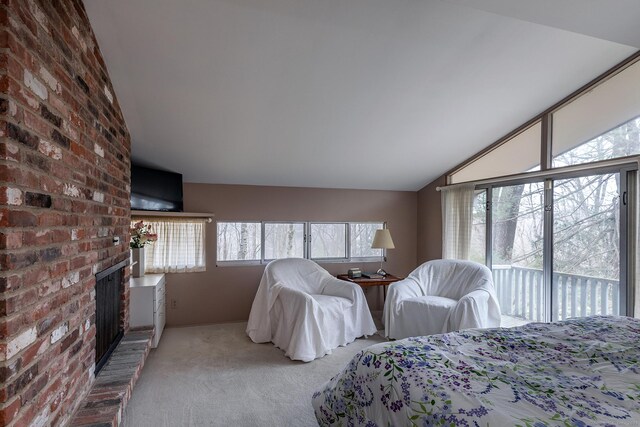 carpeted bedroom featuring lofted ceiling, brick wall, access to outside, and a brick fireplace