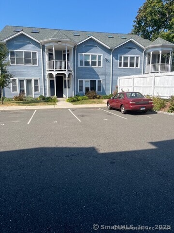 view of front of home with a balcony and fence