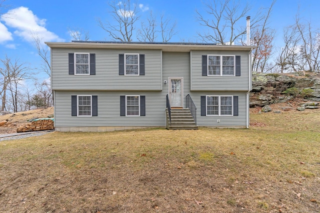 bi-level home with entry steps and a front yard