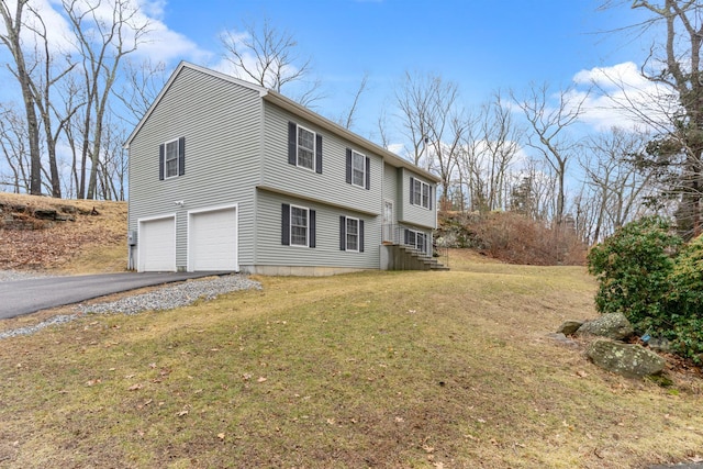 exterior space with a garage, aphalt driveway, and a yard