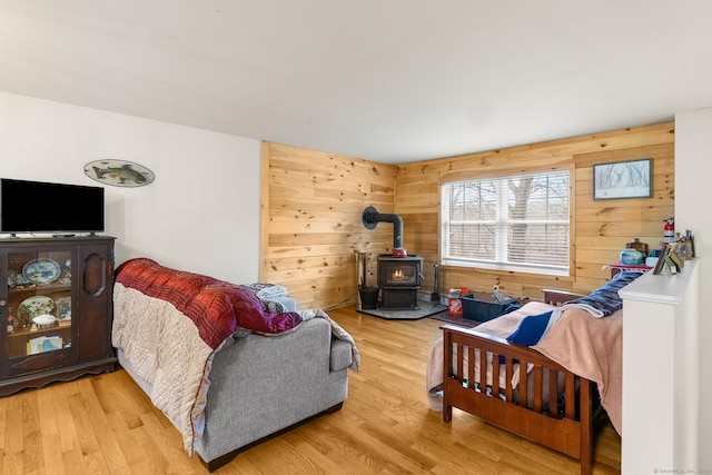 living room featuring a wood stove, wood walls, and wood finished floors