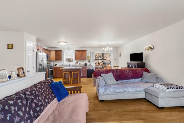 living area with light wood-type flooring and a notable chandelier