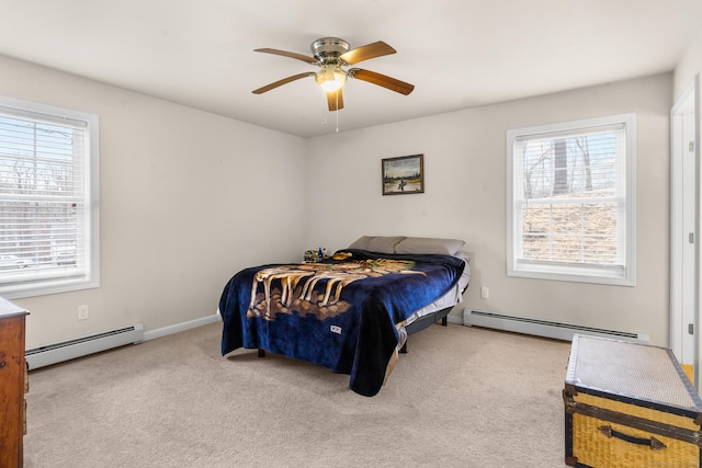 carpeted bedroom featuring a ceiling fan, multiple windows, and baseboard heating