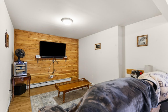 living room featuring wood walls, baseboard heating, and wood finished floors