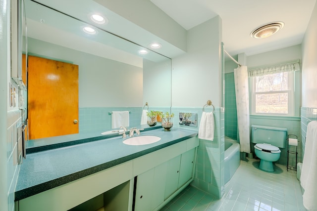 bathroom featuring toilet, tile patterned floors, vanity, tile walls, and recessed lighting