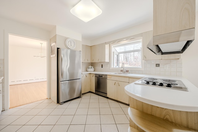 kitchen with light tile patterned floors, light countertops, backsplash, appliances with stainless steel finishes, and a sink