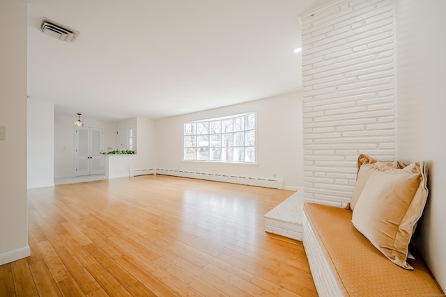 living room featuring a baseboard heating unit, visible vents, light wood-style flooring, and baseboards