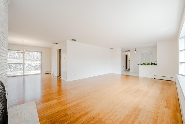 unfurnished living room featuring light wood finished floors, a fireplace, visible vents, and baseboard heating