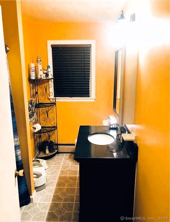 bathroom with a baseboard radiator, tile patterned flooring, and vanity