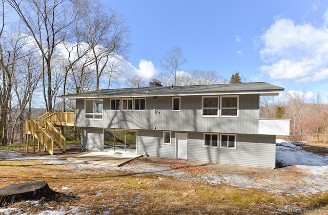 rear view of house featuring stairway, a patio, and a chimney