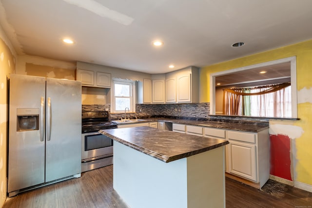 kitchen featuring dark wood-type flooring, a sink, backsplash, electric range oven, and stainless steel fridge