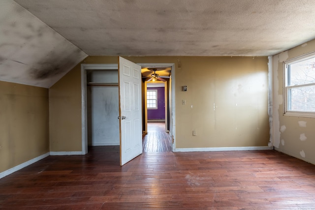 bonus room with a textured ceiling, lofted ceiling, a baseboard heating unit, baseboards, and wood-type flooring