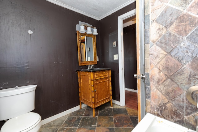 bathroom featuring baseboards, ornamental molding, toilet, and stone tile floors