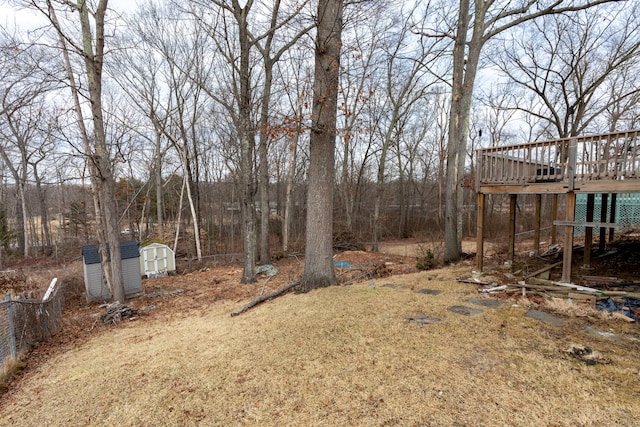 view of yard with an outbuilding, a deck, and a shed