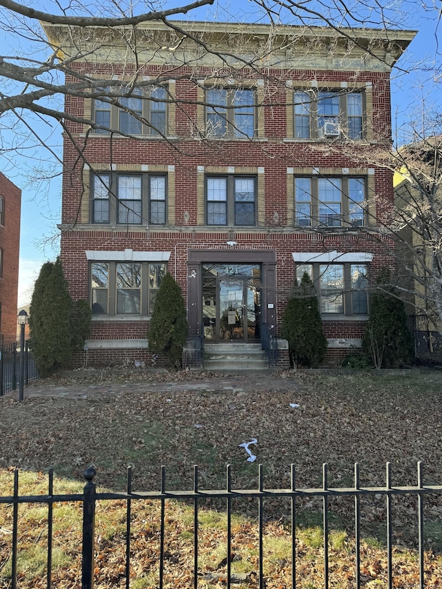 view of front of house featuring brick siding and a fenced front yard