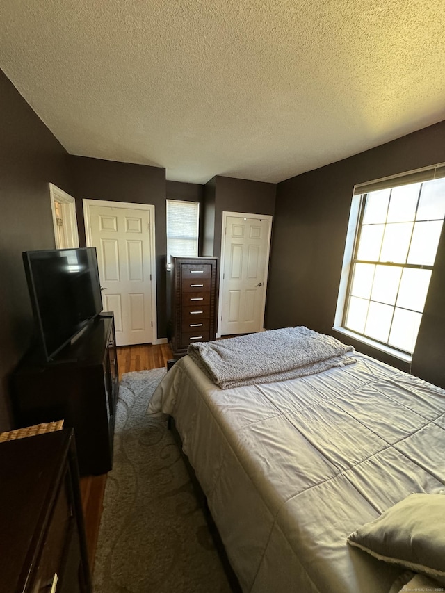 bedroom featuring a closet, a textured ceiling, and wood finished floors