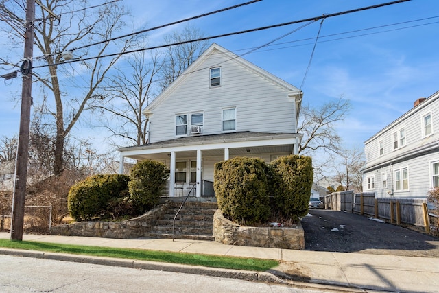 view of front of house with a porch and fence