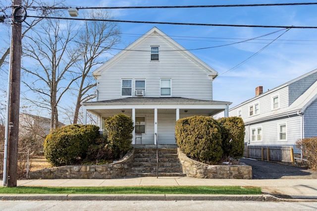 view of front of property with covered porch, cooling unit, and fence