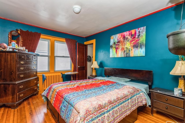 bedroom with radiator and hardwood / wood-style flooring