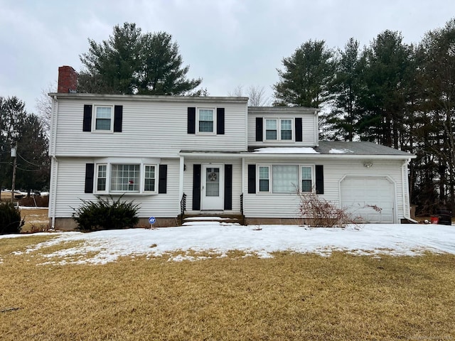 view of front of house with an attached garage, a chimney, and a lawn