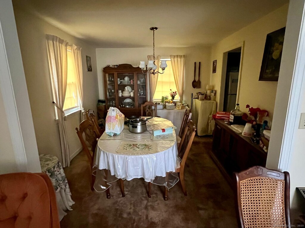343 Merline Rd, Vernon, CT 06066 - carpeted dining area featuring an inviting chandelier