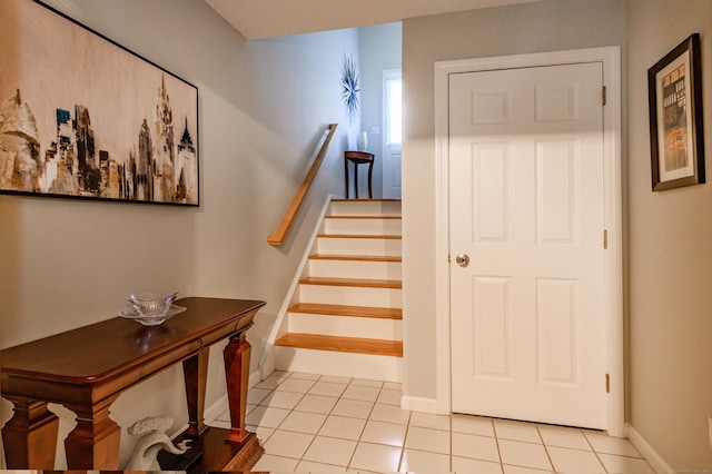 stairway with baseboards and tile patterned floors