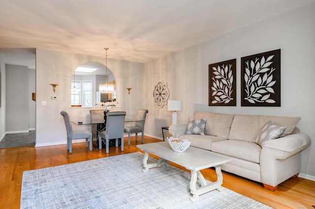 living area with a notable chandelier, baseboards, and wood finished floors