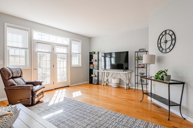 living area with baseboards and wood finished floors