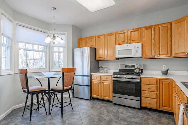 kitchen with a chandelier, stainless steel appliances, light countertops, and decorative light fixtures