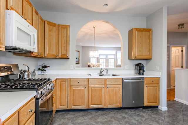 kitchen with stainless steel appliances, a chandelier, light countertops, and a sink