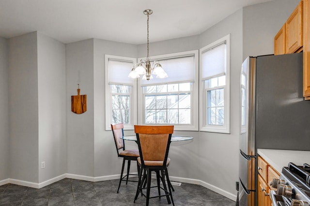 dining area with baseboards, an inviting chandelier, and a healthy amount of sunlight