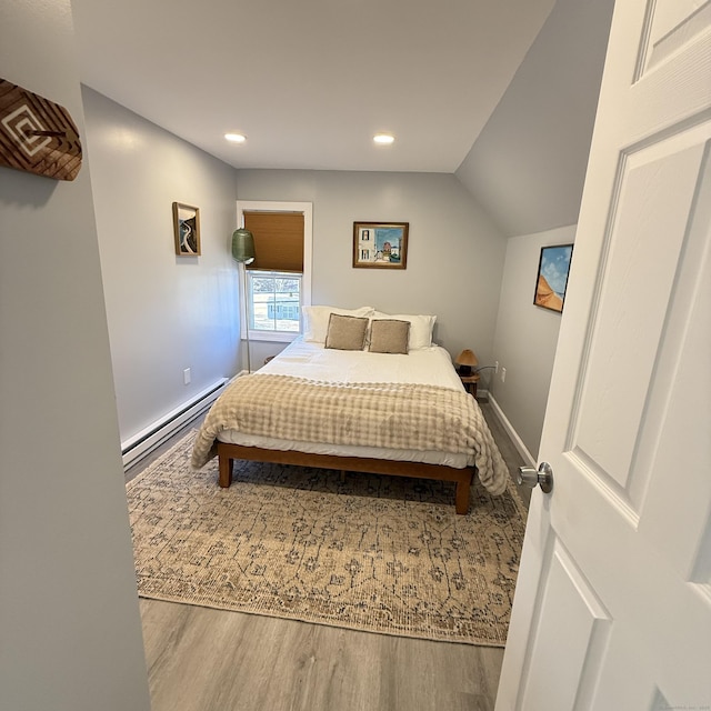 bedroom with recessed lighting, a baseboard radiator, wood finished floors, and baseboards