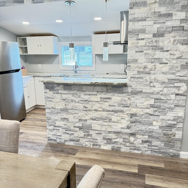 kitchen featuring a sink, white cabinetry, freestanding refrigerator, open shelves, and light wood finished floors