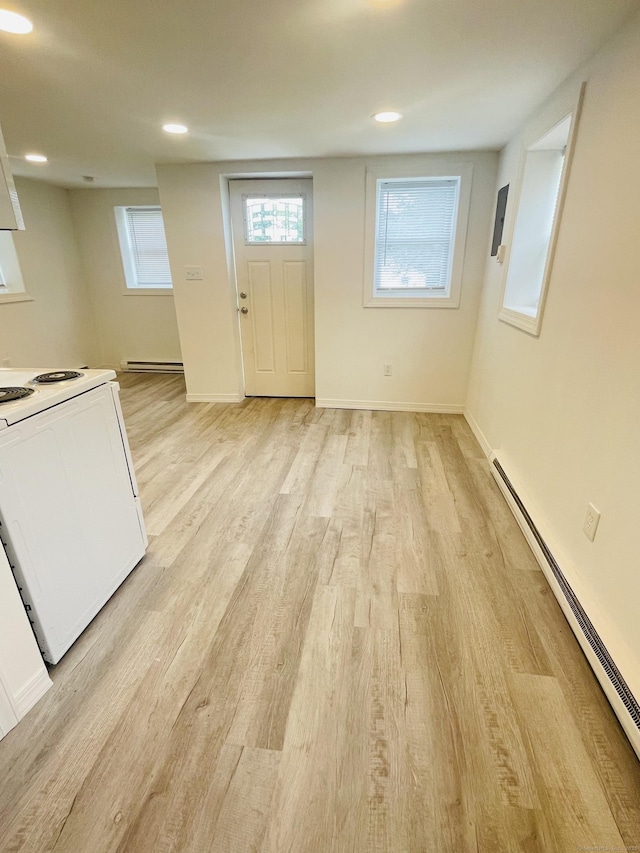 interior space featuring baseboards, baseboard heating, light wood-type flooring, a baseboard heating unit, and recessed lighting