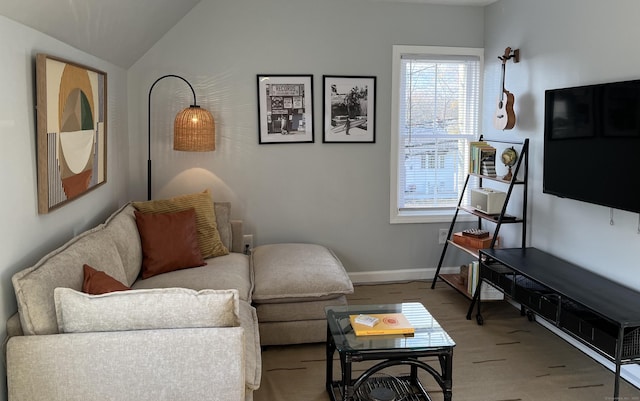 living area with lofted ceiling and baseboards