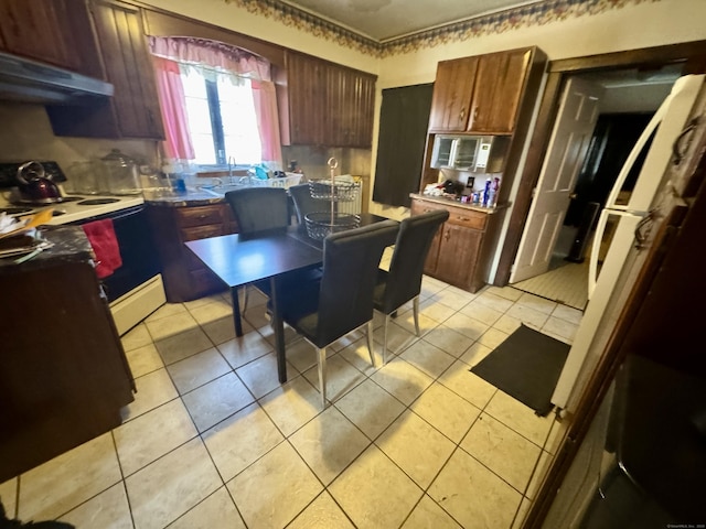 kitchen featuring electric range, stainless steel microwave, light tile patterned flooring, and under cabinet range hood